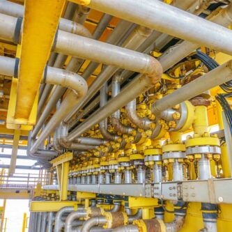 Oil pumps. Oil pump jacks at sunset sky background. Toned.